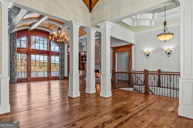 interior space with high vaulted ceiling, beamed ceiling, ornate columns, and hardwood / wood-style flooring