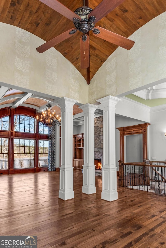 spare room with high vaulted ceiling, hardwood / wood-style flooring, wood ceiling, beam ceiling, and decorative columns