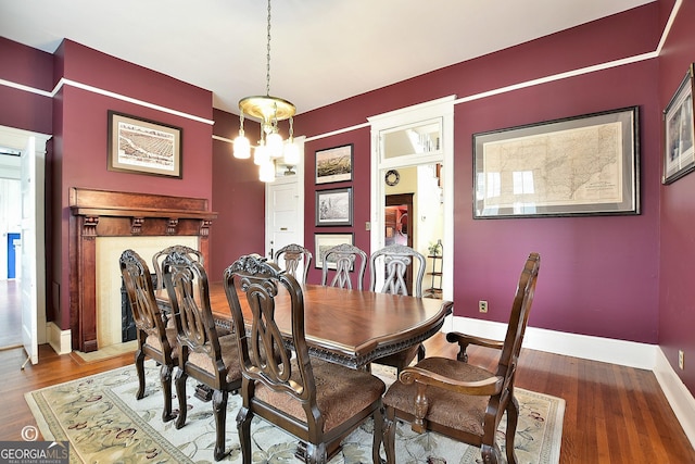 dining area with a chandelier, baseboards, and wood finished floors