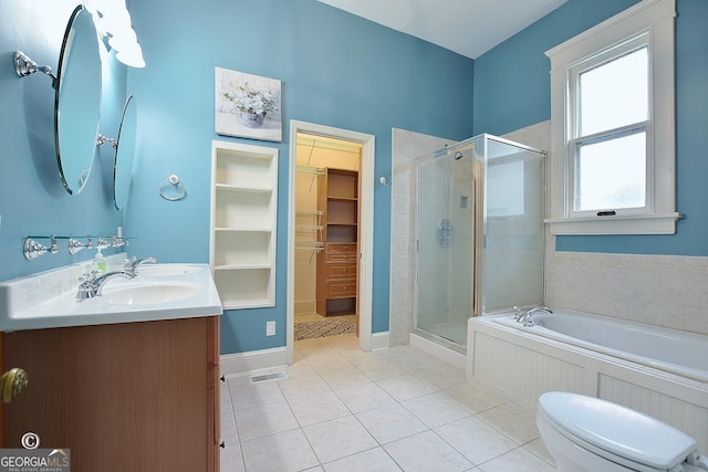 full bath featuring tile patterned flooring, a shower stall, a spacious closet, and a sink