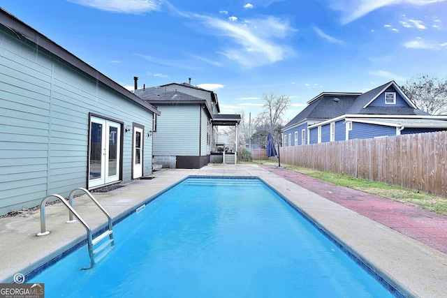 view of pool featuring french doors, a patio area, fence, and a fenced in pool