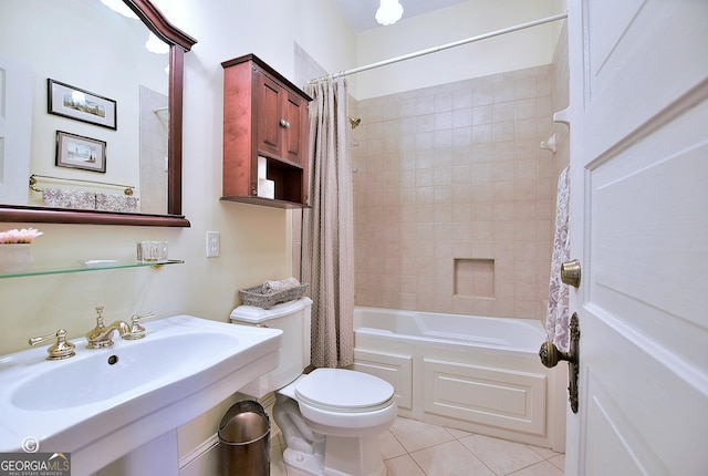 bathroom with shower / tub combo, a sink, toilet, and tile patterned floors