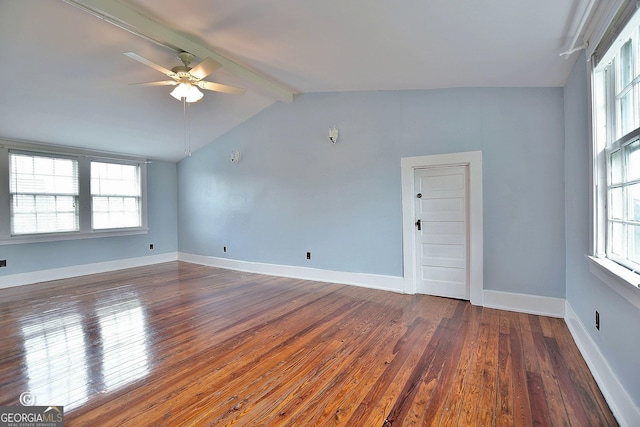 spare room featuring vaulted ceiling with beams, dark wood finished floors, plenty of natural light, and baseboards