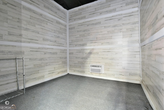 unfurnished room featuring carpet and an AC wall unit