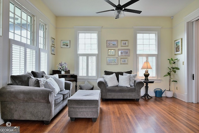 sitting room featuring ceiling fan, dark wood-style flooring, a wealth of natural light, and baseboards