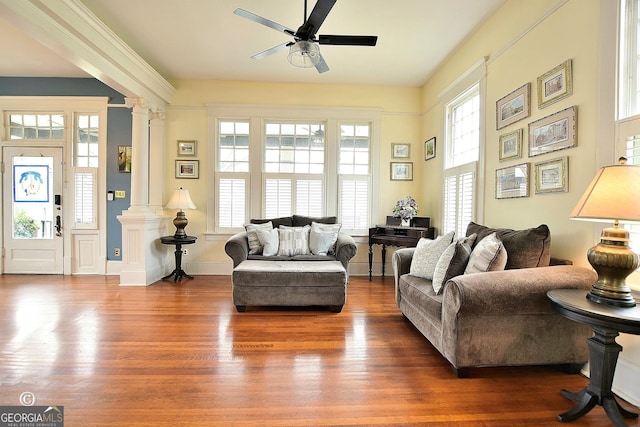 living room with ceiling fan, baseboards, wood finished floors, and ornate columns