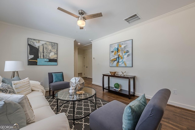 living area featuring visible vents, baseboards, wood finished floors, and crown molding