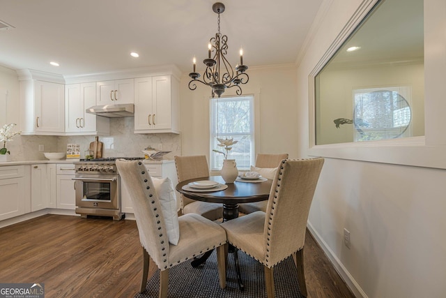 dining room with a notable chandelier, dark wood-style floors, baseboards, and ornamental molding