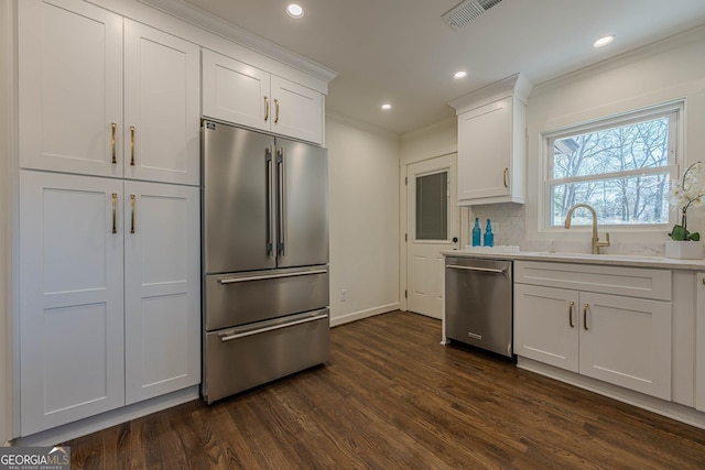 kitchen featuring visible vents, ornamental molding, dark wood-style floors, white cabinetry, and appliances with stainless steel finishes