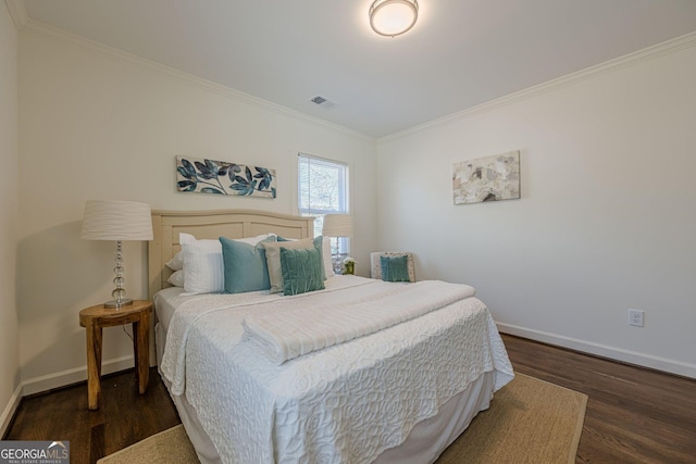 bedroom featuring visible vents, baseboards, and wood finished floors