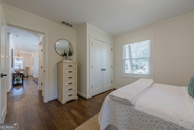 bedroom featuring crown molding, visible vents, dark wood-style flooring, and a chandelier