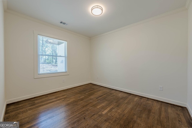 spare room with baseboards, visible vents, dark wood-style flooring, and ornamental molding