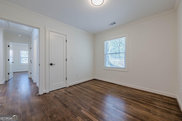 unfurnished bedroom featuring visible vents, crown molding, dark wood-type flooring, baseboards, and attic access