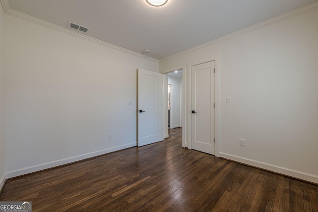 unfurnished bedroom with dark wood finished floors, baseboards, visible vents, and ornamental molding