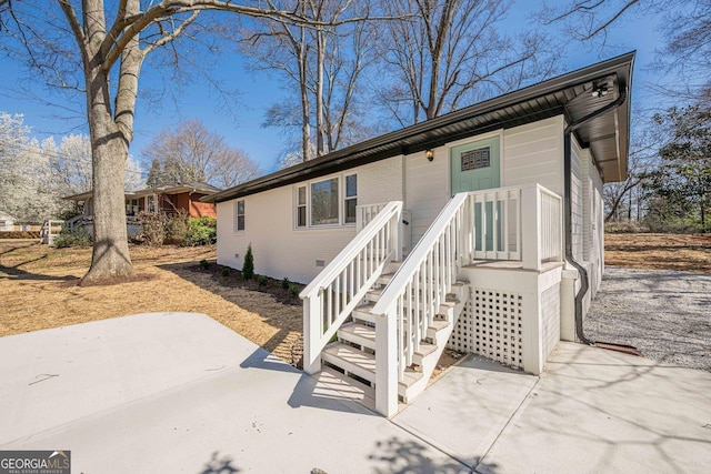 view of front of house featuring crawl space, a patio area, and brick siding