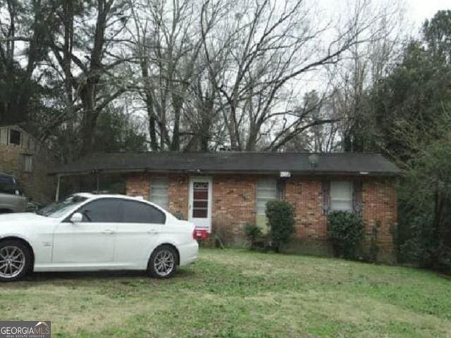 single story home with brick siding and a front yard