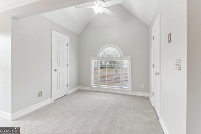 spare room with high vaulted ceiling, carpet, a ceiling fan, and baseboards