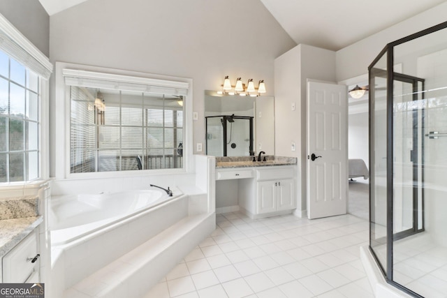 full bathroom featuring vaulted ceiling, a shower stall, vanity, a bath, and tile patterned floors