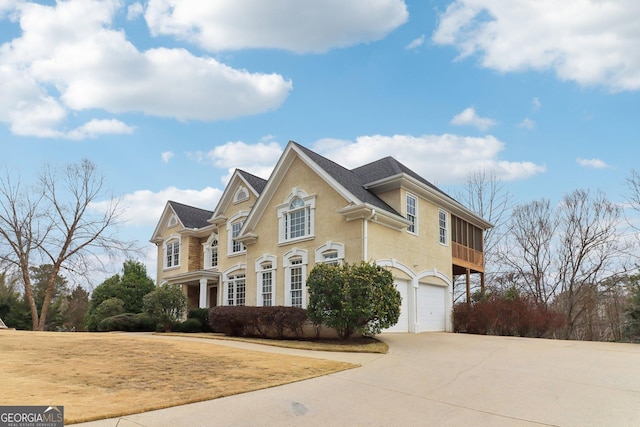 view of front of home with driveway, an attached garage, and stucco siding