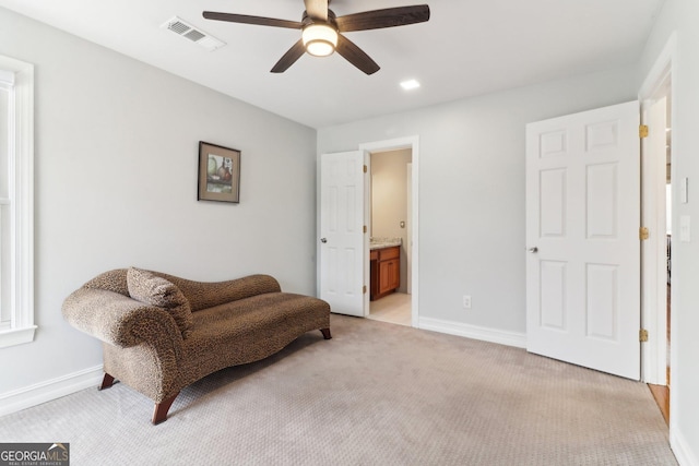 sitting room with baseboards, visible vents, ceiling fan, and light colored carpet