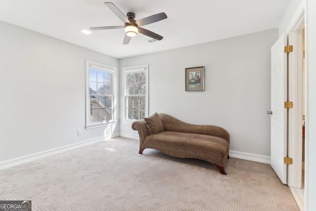 living area with carpet floors, visible vents, baseboards, and a ceiling fan