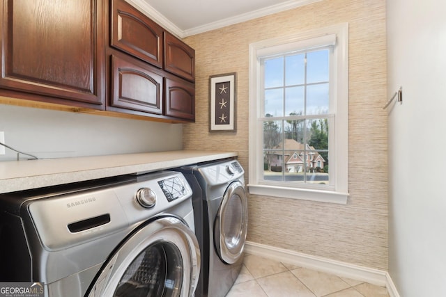 clothes washing area featuring cabinet space, baseboards, crown molding, separate washer and dryer, and light tile patterned flooring