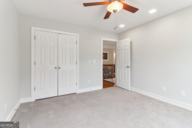 unfurnished bedroom with a closet, carpet, a ceiling fan, and baseboards