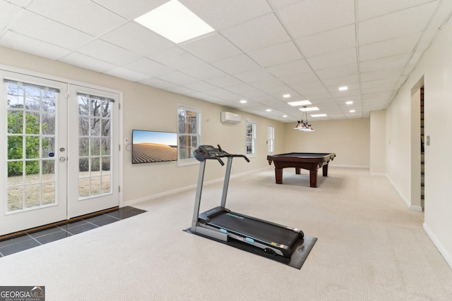 workout area with an AC wall unit, carpet flooring, a drop ceiling, and french doors