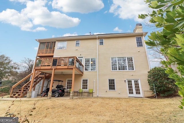 back of house featuring a sunroom, stairs, french doors, a chimney, and a patio area