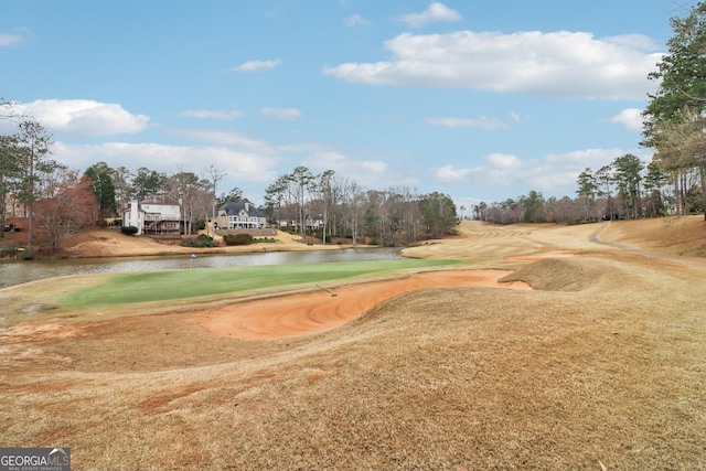 view of property's community featuring a water view, a lawn, and golf course view