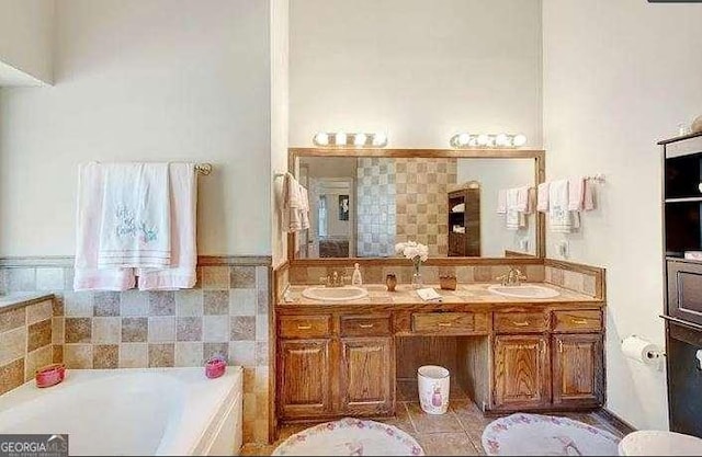 bathroom featuring double vanity, a sink, and a bath