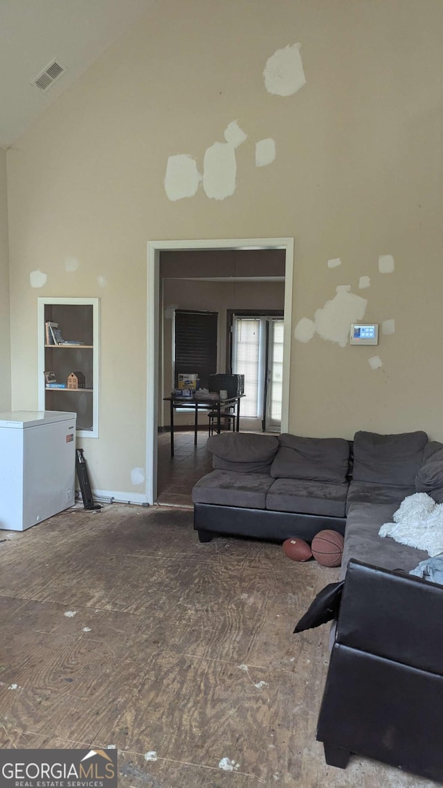 living room with high vaulted ceiling and visible vents