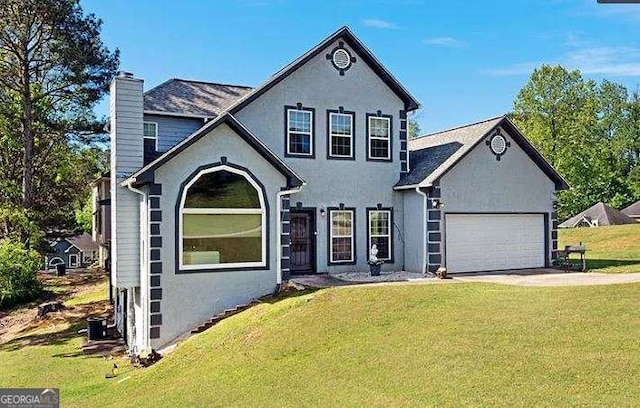 view of front facade with a chimney, stucco siding, an attached garage, a front yard, and driveway