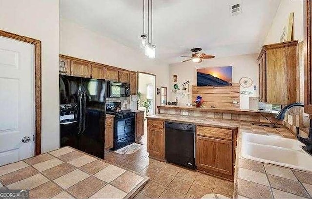 kitchen with tile countertops, a sink, visible vents, black appliances, and brown cabinetry