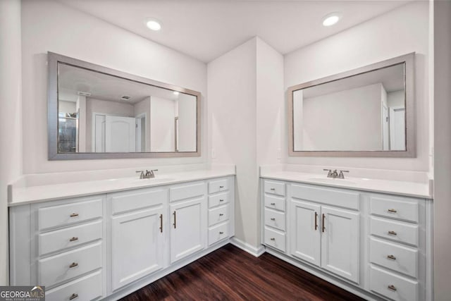 full bath featuring a sink, recessed lighting, two vanities, and wood finished floors