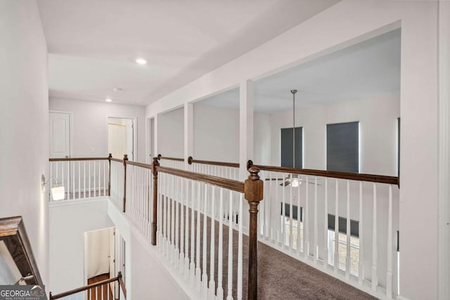 hall featuring carpet floors, an upstairs landing, and recessed lighting