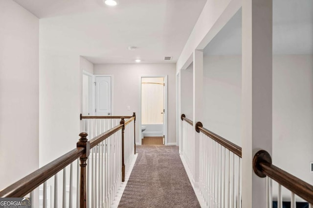 hall featuring recessed lighting, carpet floors, visible vents, baseboards, and an upstairs landing