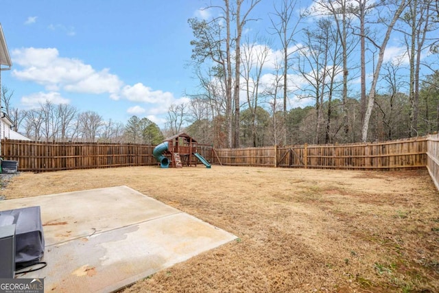 view of yard with a patio area, a fenced backyard, and a playground