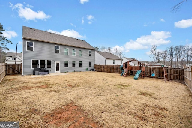 rear view of house with a yard, a fenced backyard, a playground, and a patio