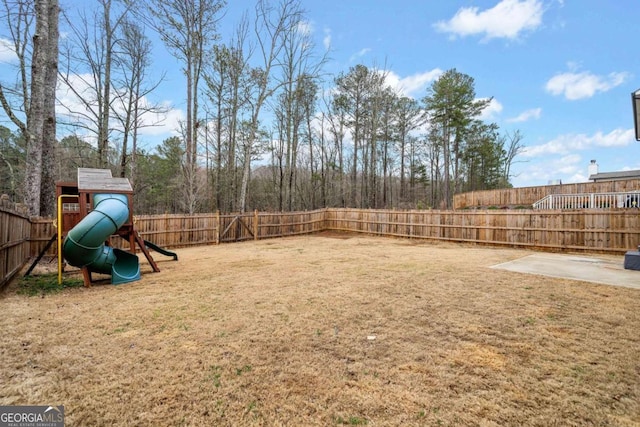 view of yard featuring a fenced backyard and a playground