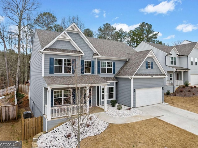 view of front facade featuring driveway, a shingled roof, fence, and central AC