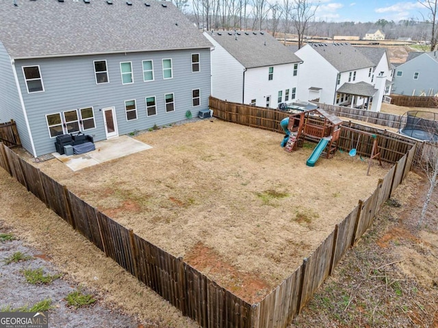 view of yard featuring a patio area, a playground, a fenced backyard, and a residential view