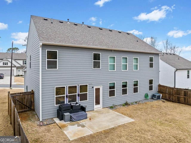 back of house featuring a shingled roof, central AC unit, a lawn, a fenced backyard, and a patio area