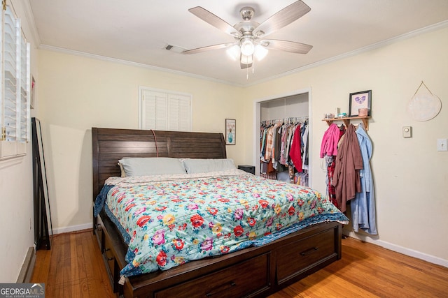 bedroom with light wood-type flooring, ornamental molding, a ceiling fan, a closet, and baseboards