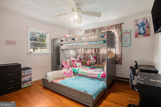 bedroom with a ceiling fan, crown molding, wood finished floors, and baseboards