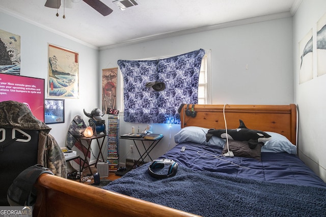 bedroom featuring visible vents, a ceiling fan, wood finished floors, and crown molding