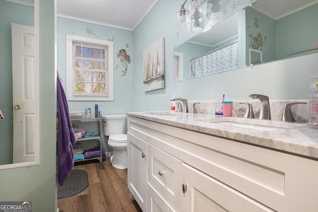 full bath featuring double vanity, wood finished floors, toilet, and a sink