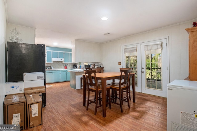 dining area featuring french doors, light wood-type flooring, and crown molding