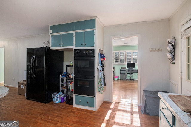 kitchen featuring black appliances, crown molding, and wood finished floors