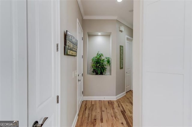 corridor featuring light wood finished floors, recessed lighting, crown molding, and baseboards